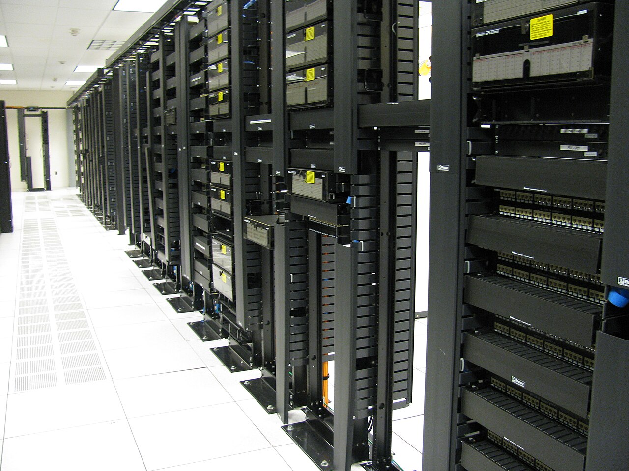 Rows of network racks and structured cabling in a modern data center aisle